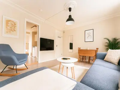 a living room with a blue couch and a table at Twin Flats 1st Floor in Bergen Centre - Norwegians Minimum Age 25 in Bergen