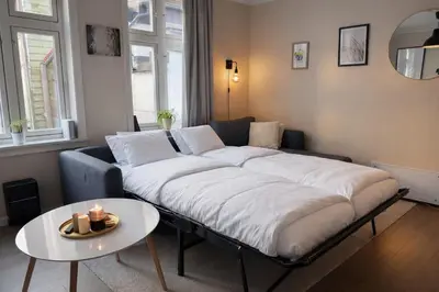 a large bed in a living room with a table at Twin Flats 1st Floor in Bergen Centre - Norwegians Minimum Age 25 in Bergen