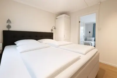 a white bed with white sheets and a black headboard at Twin Flats 1st Floor in Bergen Centre - Norwegians Minimum Age 25 in Bergen