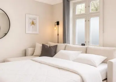a white bedroom with a white couch and windows at Trio Central in centre - Norwegians Minimum Age 25 in Bergen