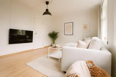 a living room with a white couch and a table at Quartet Bryggen Central - Quiet and Cozy - Norwegians Minimum Age 25 in Bergen