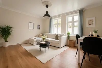 a living room with a white couch and a table at Quartet Bryggen Central - Quiet and Cozy - Norwegians Minimum Age 25 in Bergen