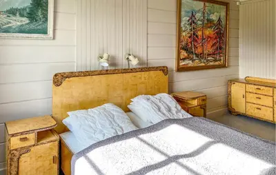 a bedroom with a bed and a painting on the wall at Lovely Home In Fiksdalen in Fiksdal