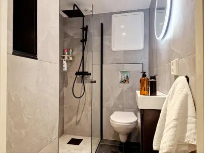 a bathroom with a shower and a toilet and a sink at Renovated retreat in beautiful area near Bryggen in Bergen