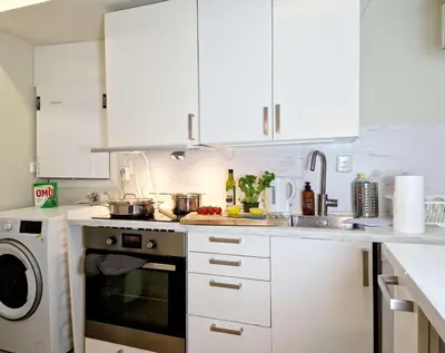 a kitchen with white cabinets and a stove top oven at Renovated retreat in beautiful area near Bryggen in Bergen