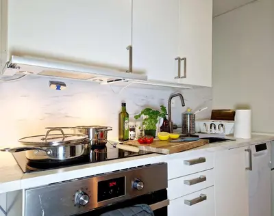 a kitchen with white cabinets and a stove at Renovated retreat in beautiful area near Bryggen in Bergen
