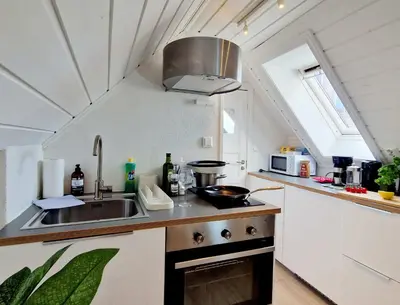 a kitchen with a sink and a stove at Cozy loft with king bed in the middle of town in Bergen