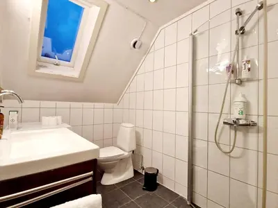a bathroom with a toilet and a sink and a shower at King bed Great location Top floor in Bergen