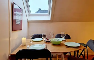 a wooden table with plates and wine glasses on it at King bed Great location Top floor in Bergen