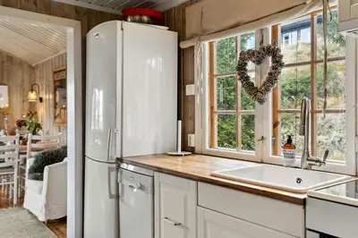 a kitchen with a refrigerator and a window at Charming Cabin By Nesfjellet Ski Resort in Nesbyen
