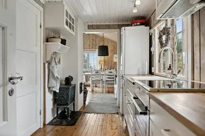 a kitchen with white cabinets and a wooden floor at Charming Cabin By Nesfjellet Ski Resort in Nesbyen