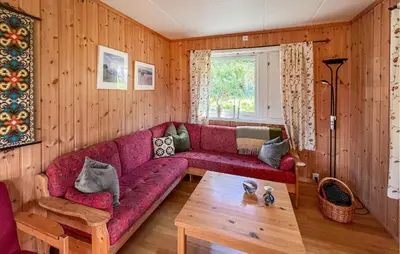 a living room with a red couch and a table at 3 Bedroom Stunning Home In Sør-Fron in Sør-Fron