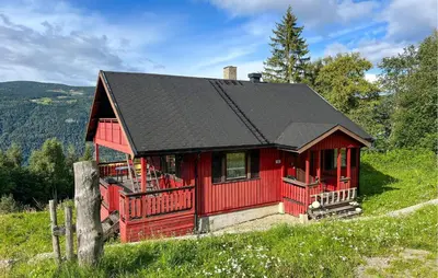 a red cabin with a black roof on a hill at 3 Bedroom Stunning Home In Sør-Fron in Sør-Fron