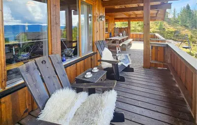a porch of a cabin with two chairs and a table at Awesome Home In Eggedal With Sauna in Eggedal