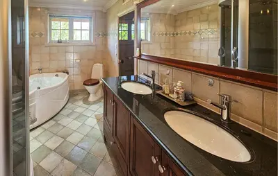 a bathroom with two sinks and a bath tub and a tubermott at Awesome Home In Eggedal With Sauna in Eggedal