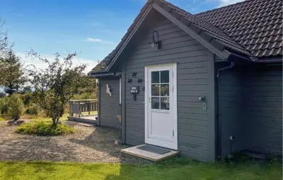a black house with a white door and a yard at Stunning Home In Korssund With Wifi in Korssund