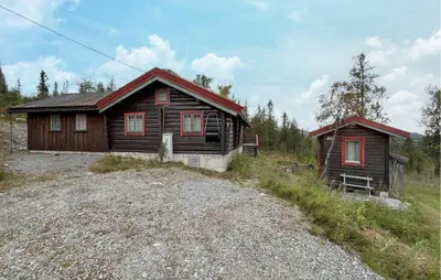 a wooden house with a red roof in a field at 4 Bedroom Lovely Home In Nord-Torpa - N31585 in Nord Torpa