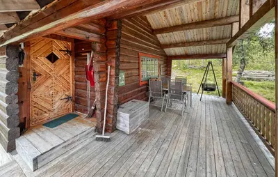a porch of a wooden cabin with a table at 4 Bedroom Lovely Home In Nord-Torpa - N31585 in Nord Torpa