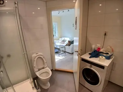 a bathroom with a toilet and a washing machine at 2 Bedroom central apartment in Bergen