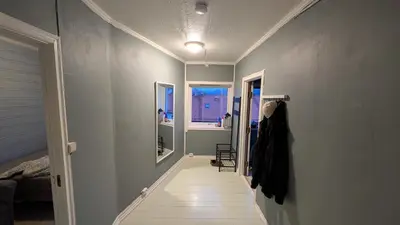 a hallway leading to a room with two windows at 2 Bedroom central apartment in Bergen