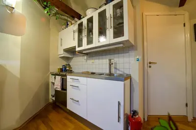 a kitchen with white cabinets and a sink at Penthouse in Bergen