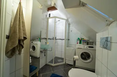 a bathroom with a sink and a washing machine at Penthouse in Bergen