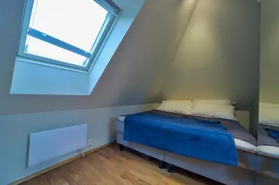 a bed in a small room with a window at Penthouse in Bergen