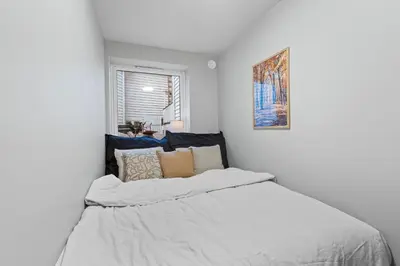 a bedroom with a large bed with white sheets at Modern Apartment in the Heart of Bergen in Bergen