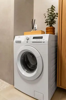 a white washing machine in a room with a plant at Modern Apartment in the Heart of Bergen in Bergen