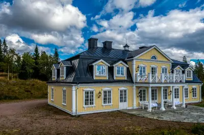 a large yellow house with a black roof at Villa Grøndalen Gård in Trysil