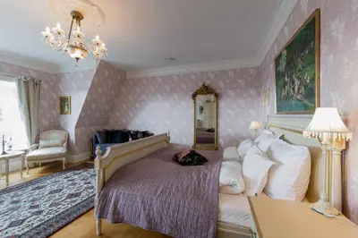 a bedroom with a bed in a room with pink wallpaper at Villa Grøndalen Gård in Trysil
