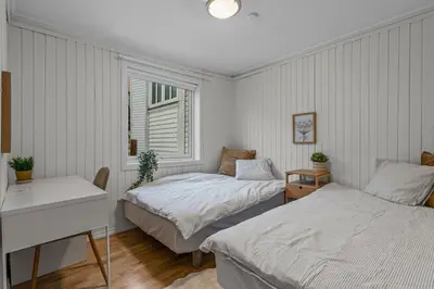 a bedroom with two beds and a desk and a window at Large Historic Apartment in the best part of Bergen in Bergen