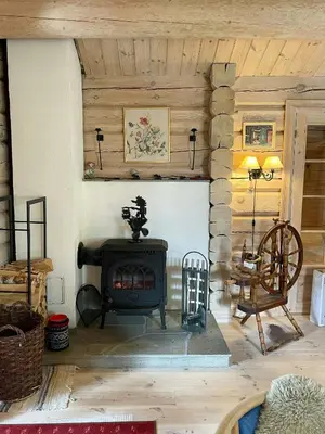 a fireplace in a living room with a stove at Traditional Log Cabin By Lake Mykletjønn in Austbygdi