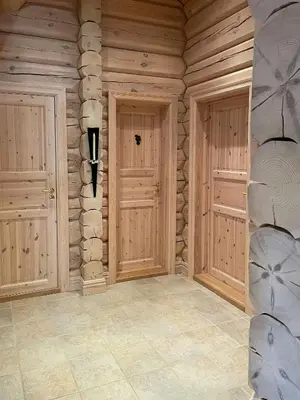 a room with two doors in a wooden wall at Traditional Log Cabin By Lake Mykletjønn in Austbygdi