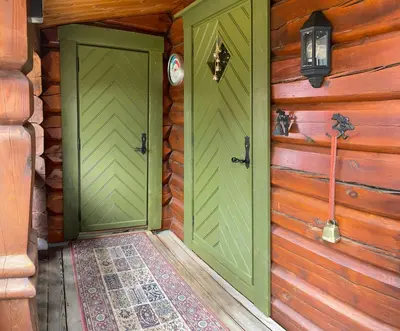 two green doors in a log cabin with a rug at Traditional Log Cabin By Lake Mykletjønn in Austbygdi