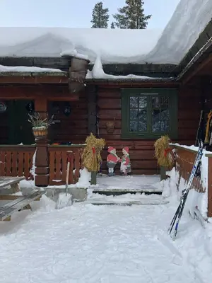two gnomes standing on the front porch of a log cabin at Traditional Log Cabin By Lake Mykletjønn in Austbygdi