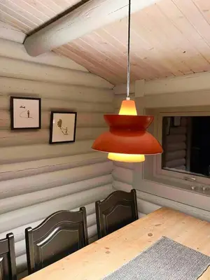 a dining room with a table and chairs and a lamp at Modernized Log Cabin At Ljøsheim in Sjusjøen