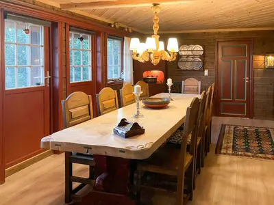 a dining room with a wooden table and chairs at Spacious Family Cabin With Views In Hafjell in Øyer