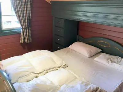 a bed with white sheets and pillows in a room at Spacious Family Cabin With Views In Hafjell in Øyer