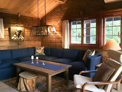 a living room with a blue couch and a table at Spacious Family Cabin With Views In Hafjell in Øyer