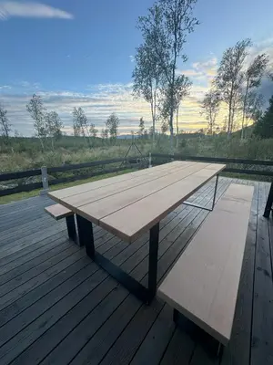 a wooden picnic table and benches on a deck at Mountain Cabin With Beautiful Lake View in Hemsedal