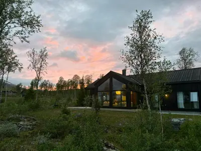 a house in the middle of a field at Mountain Cabin With Beautiful Lake View in Hemsedal
