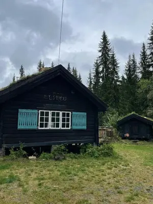 a black house with a window on the side of it at Traditional Log Cabin By Lake Seljord in Seljord