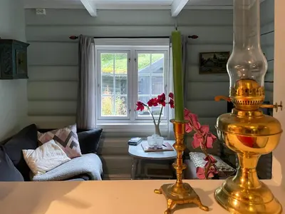 a living room with a couch and a vase on a table at Traditional Log Cabin By Lake Seljord in Seljord