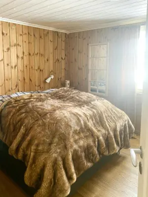 a bedroom with a bed with a blanket at Family Cabin By The Ski Trails In Rauland in Seljord