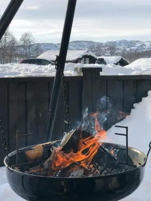a grill with a fire in it in the snow at Family Cabin By The Ski Trails In Rauland in Seljord