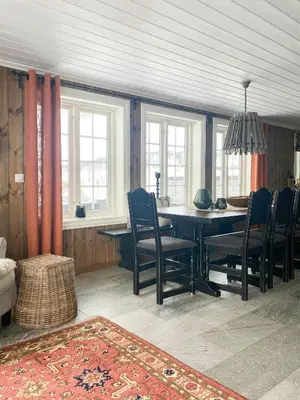 a dining room with a table and chairs and windows at Family Cabin By The Ski Trails In Rauland in Seljord