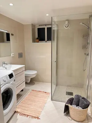 a bathroom with a shower and a washing machine at Free parking grand floor Apartment in Ålesund in Ålesund