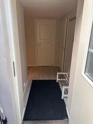 an empty hallway with a door and a black rug at Free parking grand floor Apartment in Ålesund in Ålesund