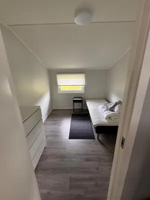 a small room with a bed and a window at Steinkjer, 5 room apartment in Steinkjer